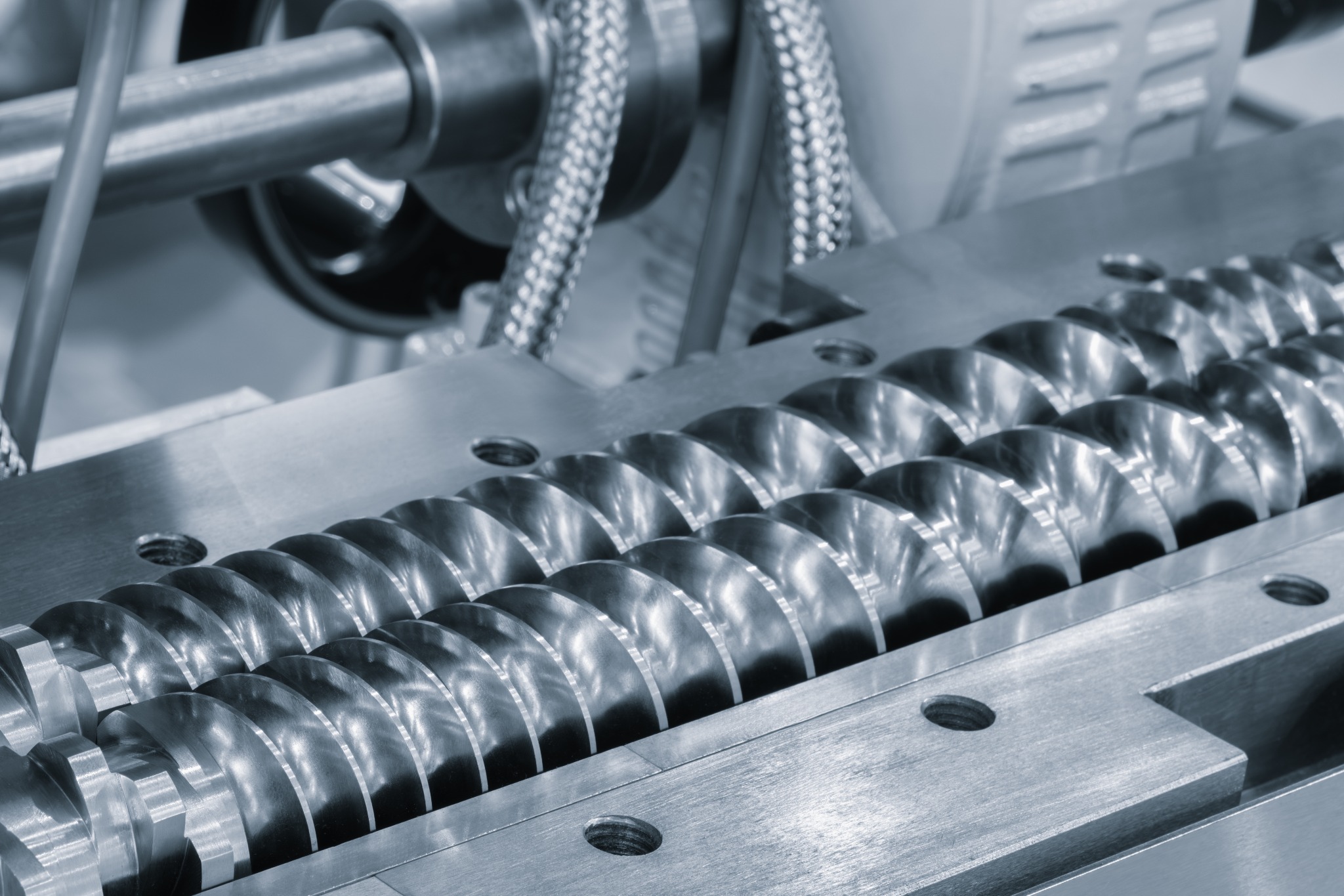 Close-up of intermeshing screws in polymer compounding equipment