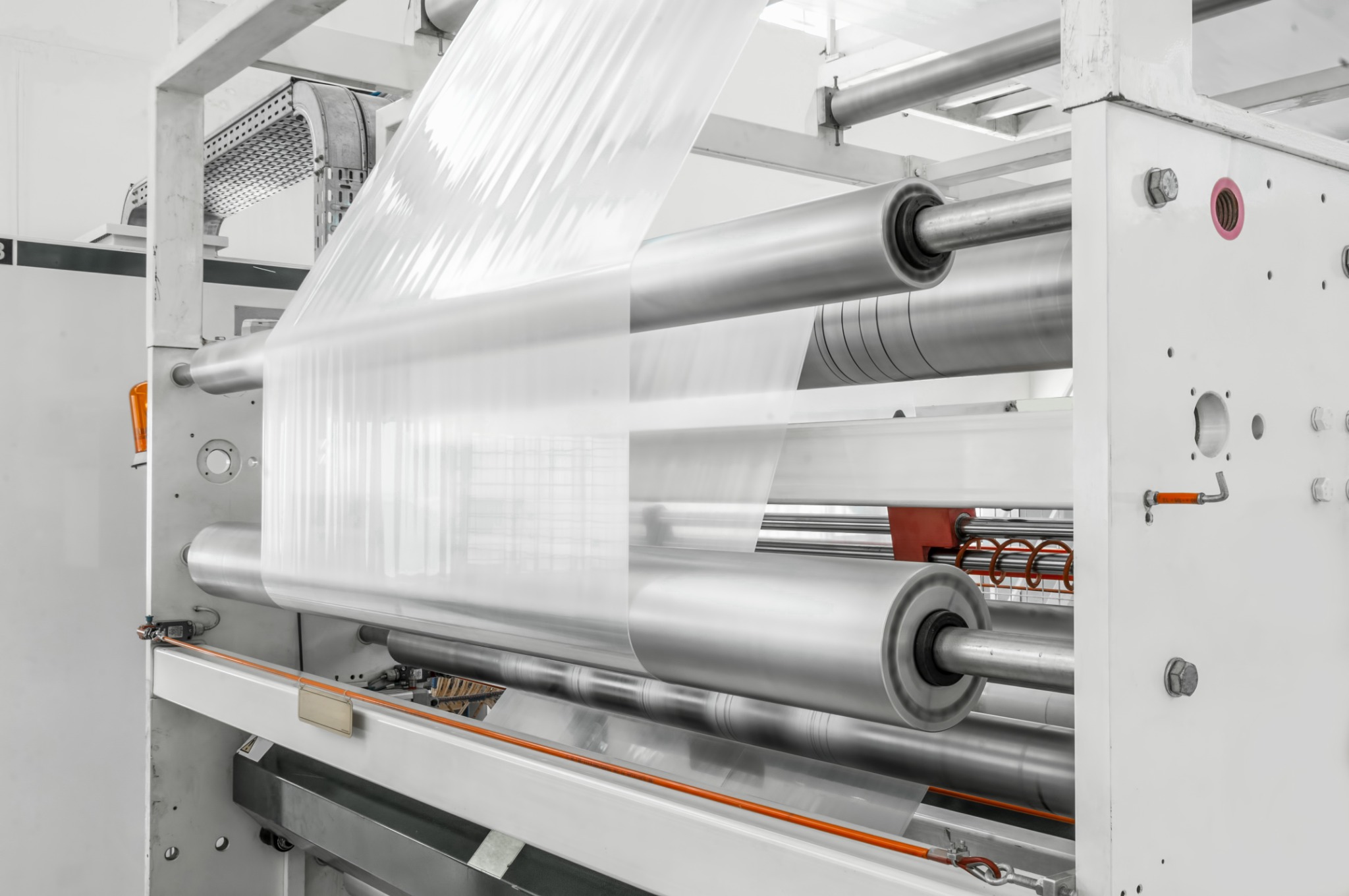 Transparent polymer film passing over rollers in a production line